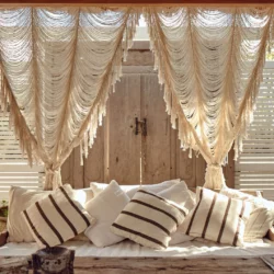 boho curtains made out of macrame over a bed with sun shining in